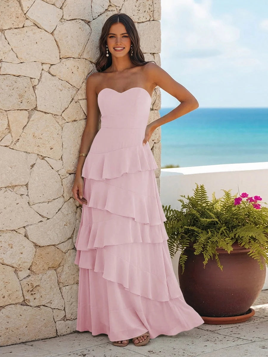 Pastel pink strapless sweetheart maxi dress with layered ruffle tiers and peplum bodice