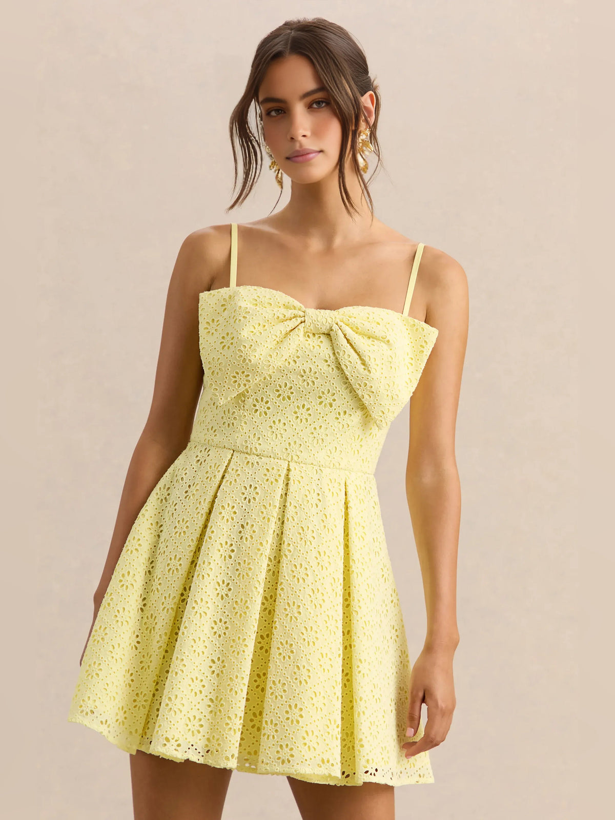 Lemon yellow eyelet mini dress with sweetheart neckline, bow detail, and flared pleated skirt