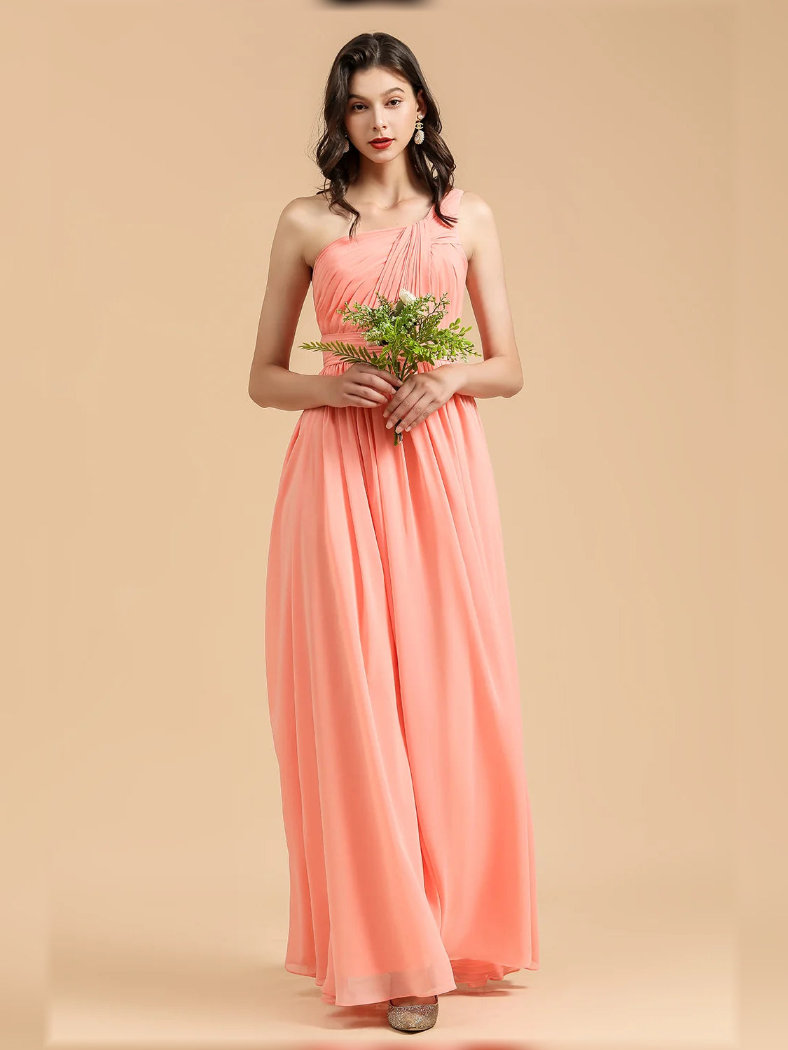 Coral one-shoulder pleated A-line chiffon maxi dress, front view with bouquet.