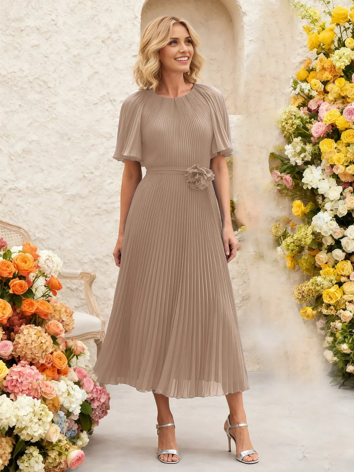 Taupe pleated chiffon midi dress with flutter sleeves and floral waist detail.