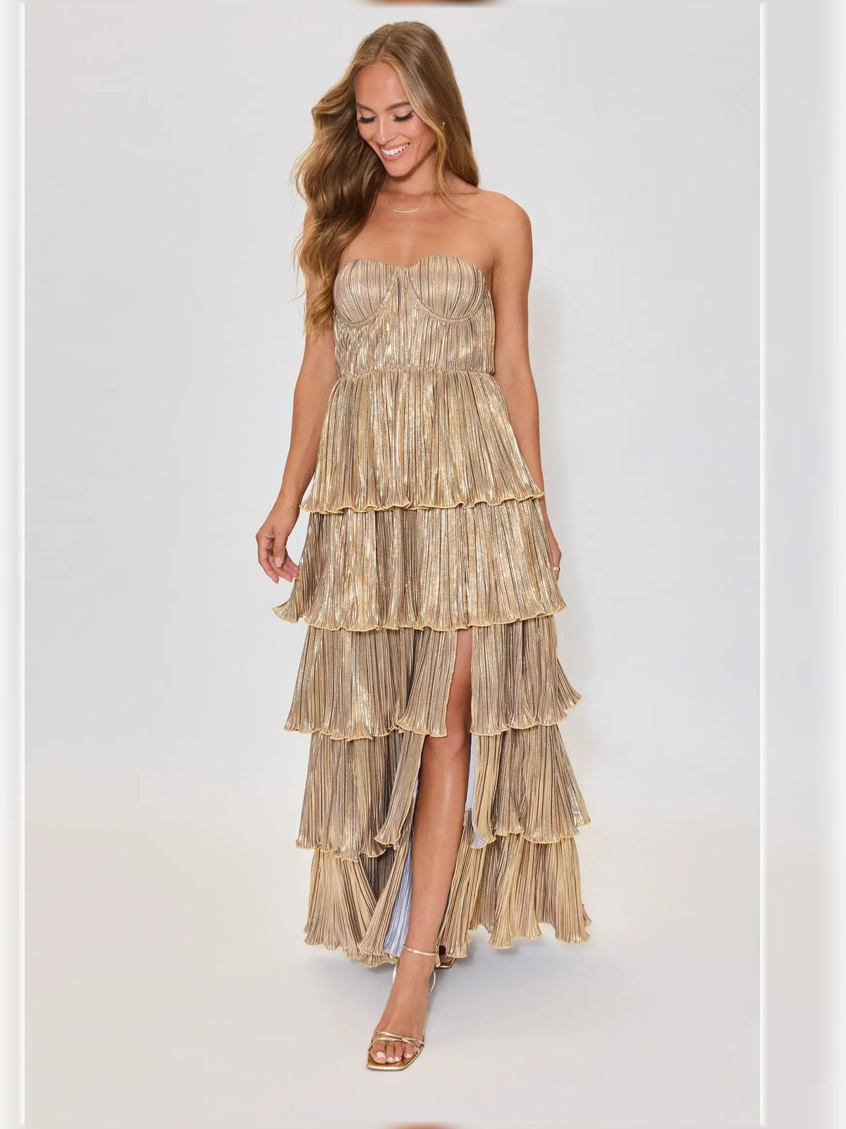 Gold strapless pleated tiered formal dress with flowing tiered skirt