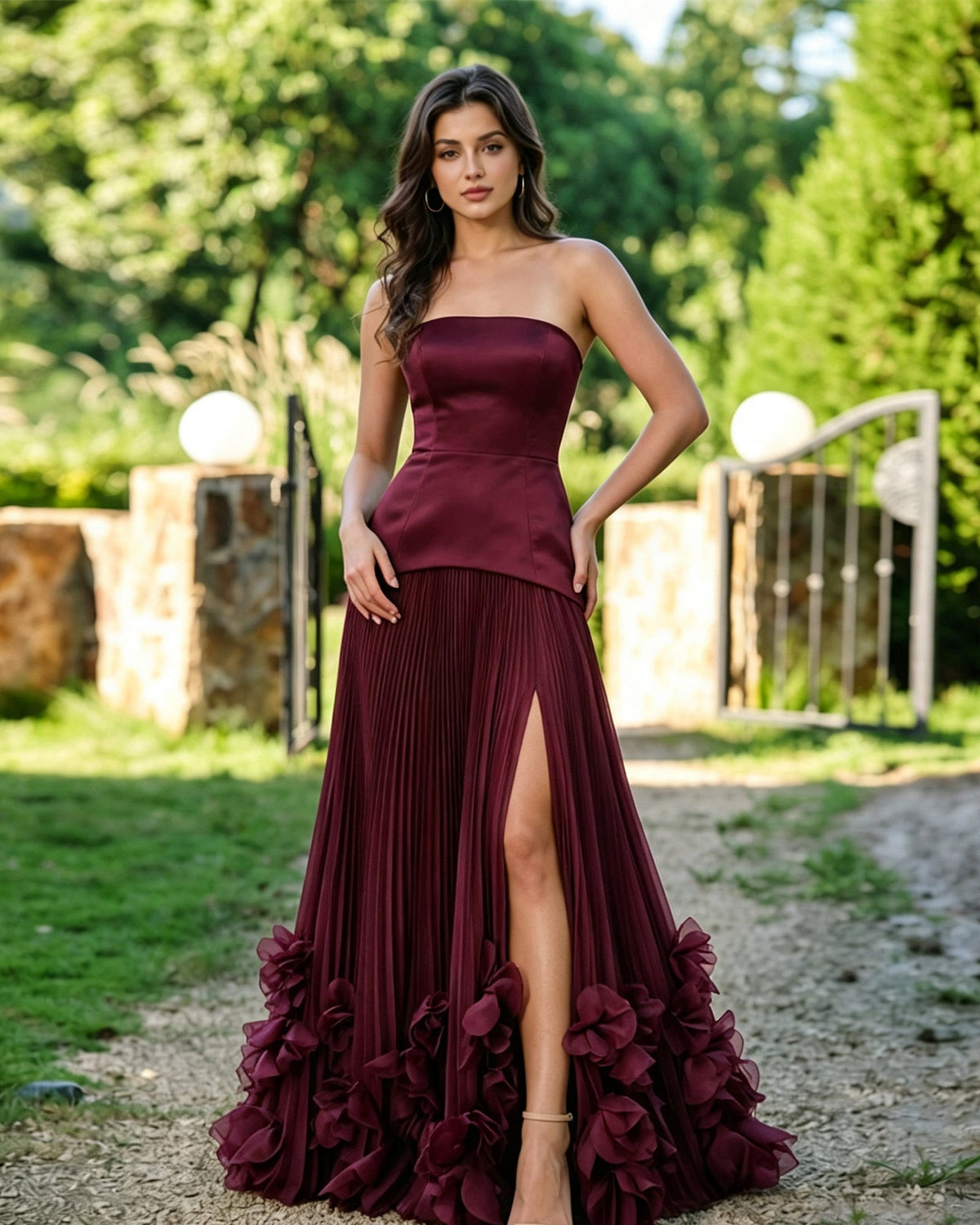 Strapless formal dress in burgundy satin, pleated slit skirt with floral ruffle hem