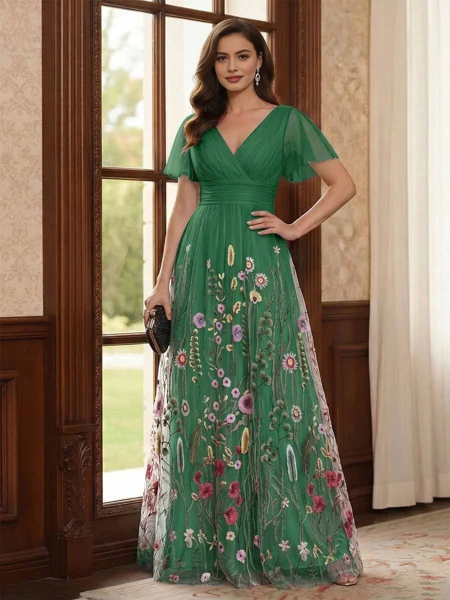 Emerald green V-neck A-line tulle dress with ruched waist, flutter sleeves, floral embroidery.