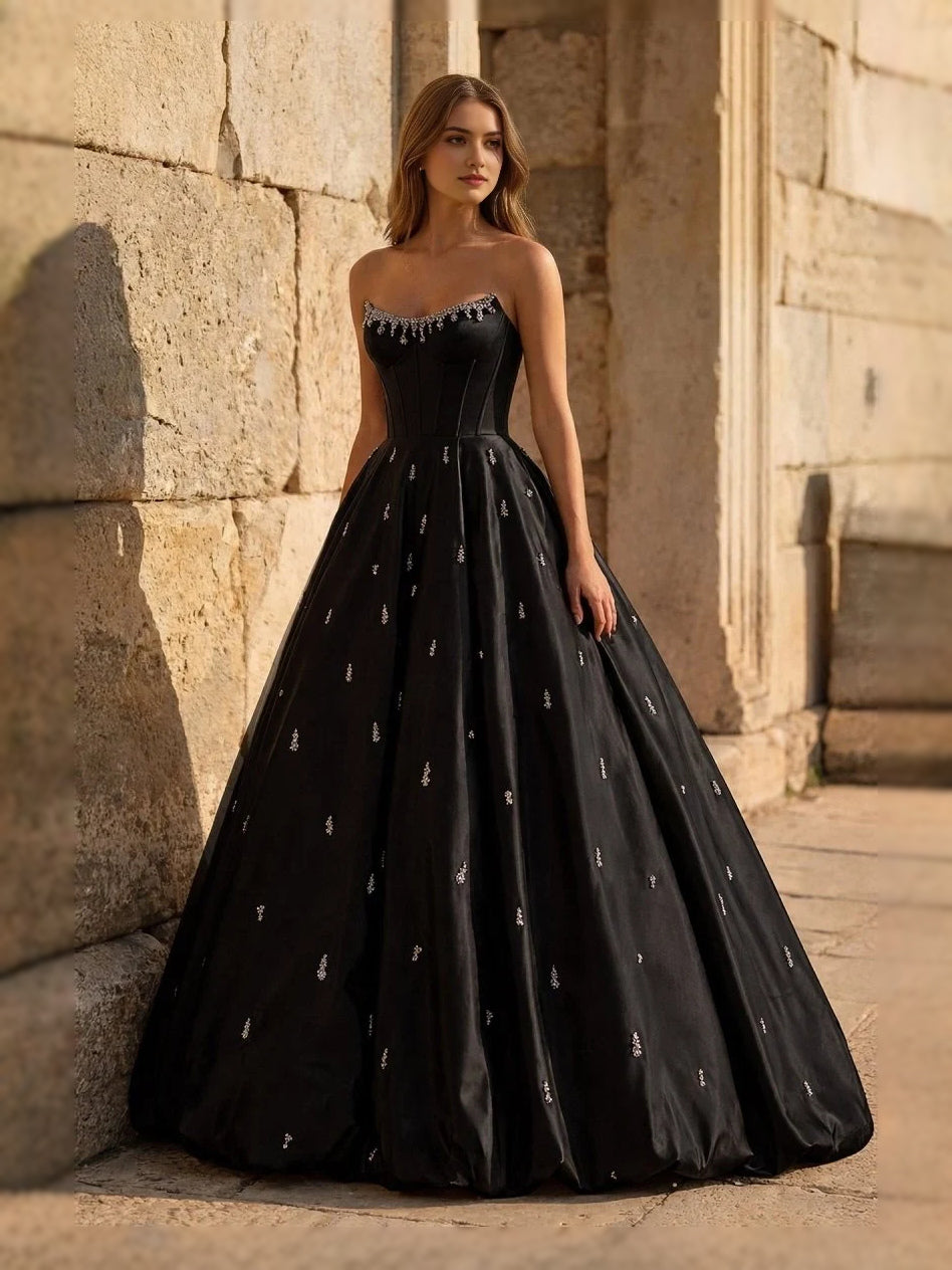 Black sweetheart corset ball gown with voluminous tulle skirt and gold sparkle dots