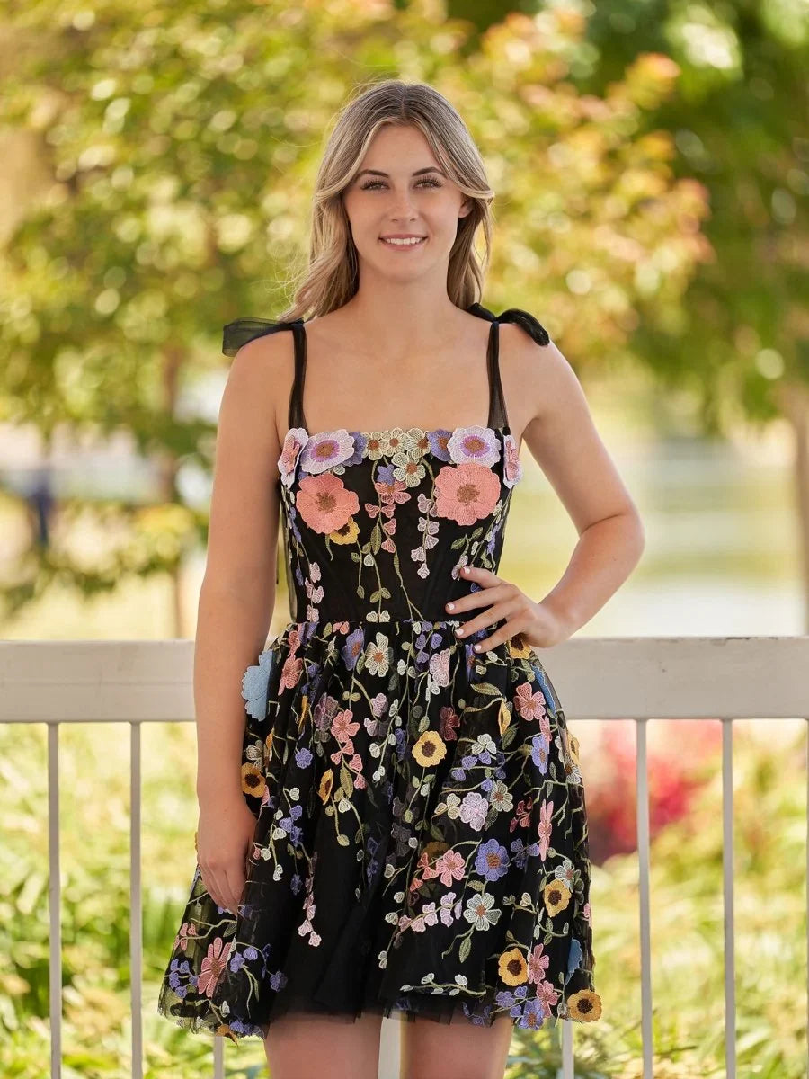 Black floral mini tulle dress with square neckline and corset-style bodice, tiered skirt.