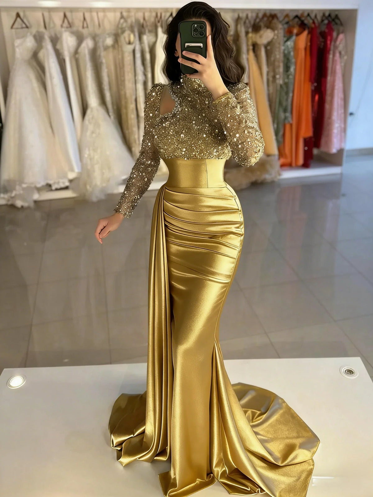 Gold mermaid formal dress with shimmering long sleeves, corset bodice, and slit
