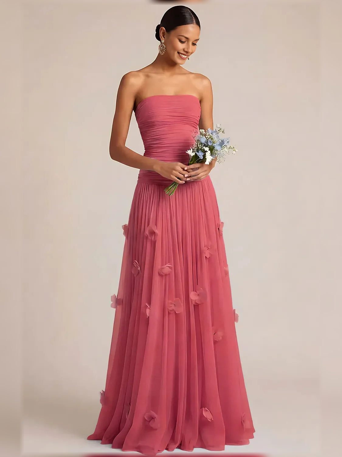 Pink strapless ruched formal dress with floor-length pleated skirt and floral appliques