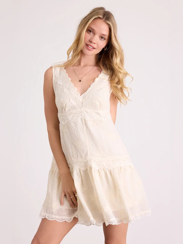 Cream sleeveless tiered mini dress with V-neck and scalloped lace edges
