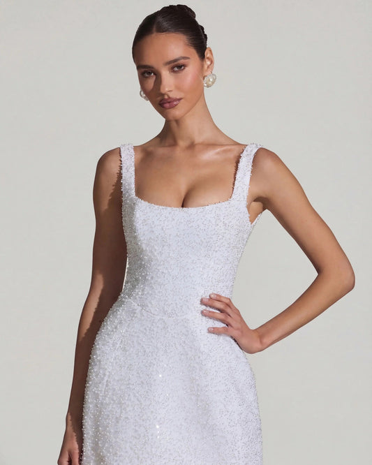 White mini dress with square neckline, sleeveless straps, and A-line embellished skirt