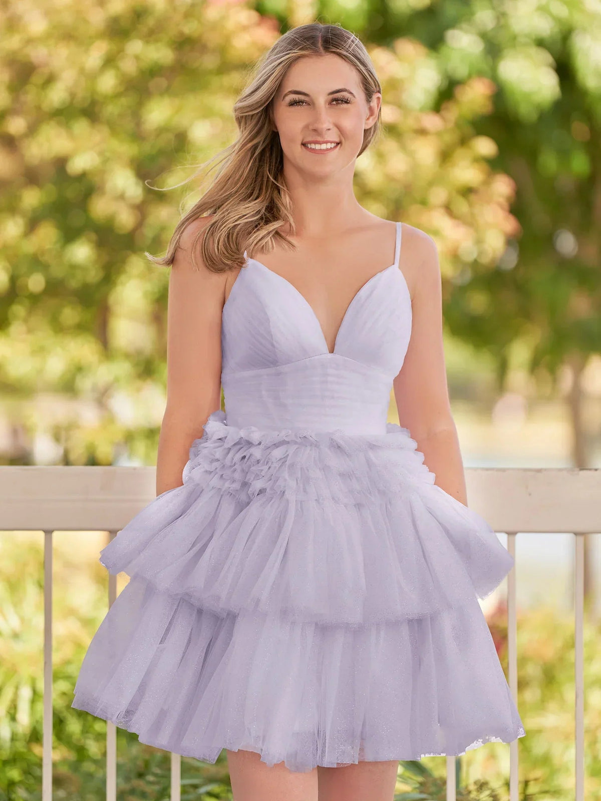 Lilac tulle mini dress with V-neck, spaghetti straps, and layered ruffle skirt.