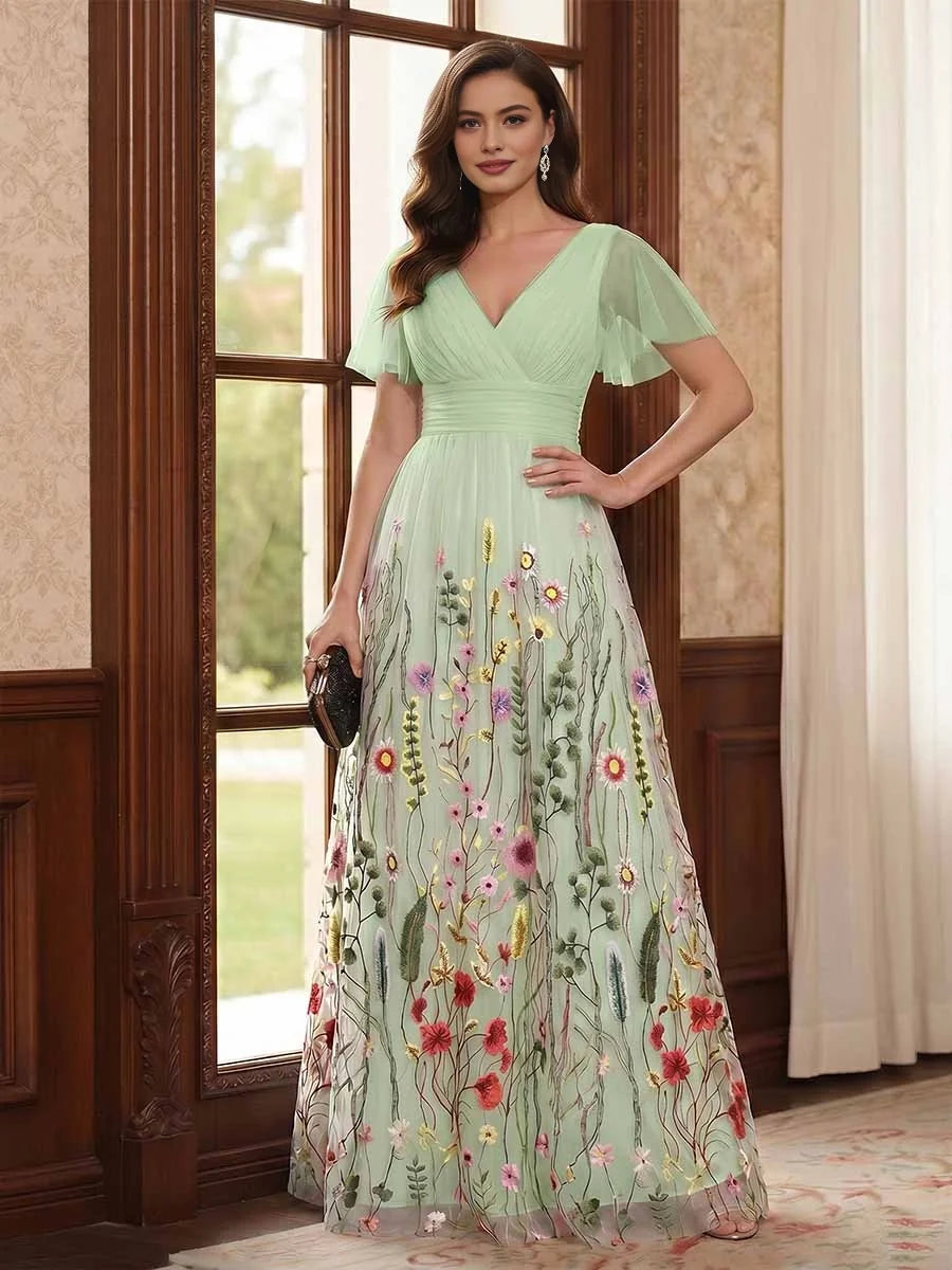 Mint green V-neck A-line tulle dress with ruched waist, flutter sleeves, floral embroidery.
