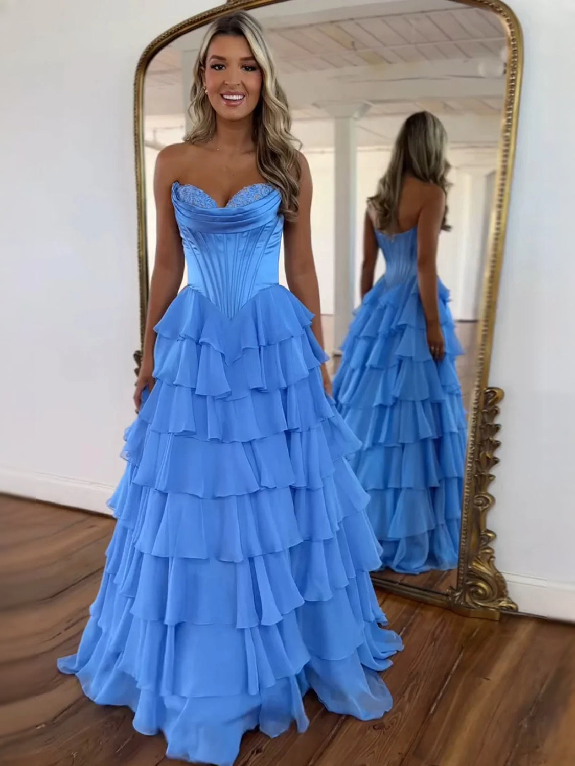 Blue strapless corset prom dress with tiered ruffle skirt and layered skirt hem.