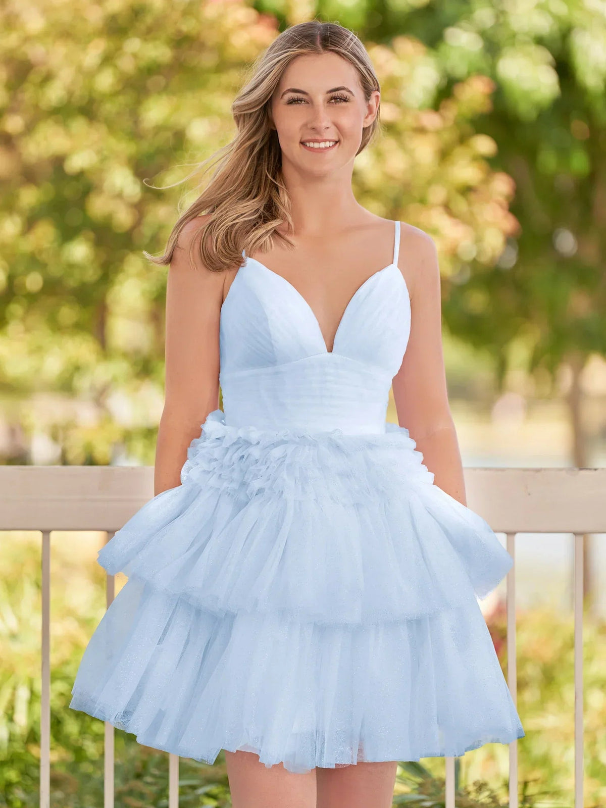 Light blue tulle mini dress with V-neck, spaghetti straps, and layered ruffle skirt.