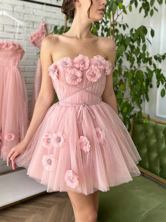 Light pink strapless tulle mini dress with floral appliques and bow-tied waist ribbon