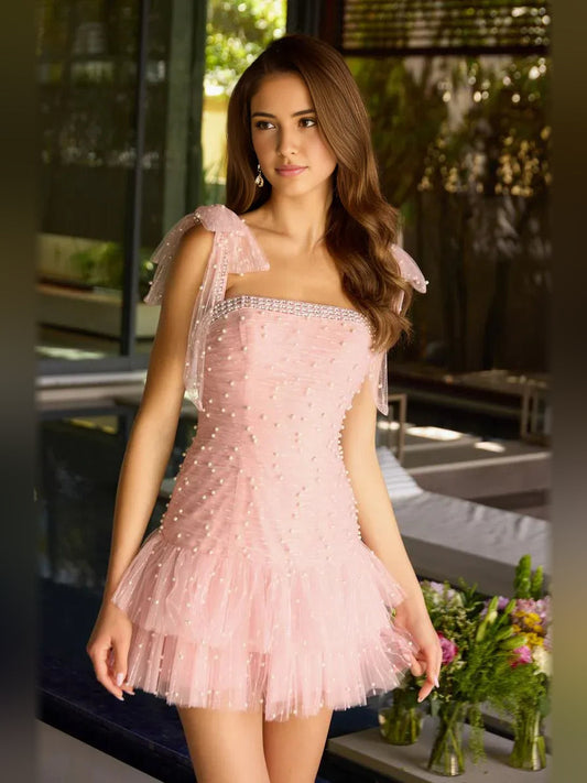 Blush pink mini tulle dress with straight neckline and layered ruffle hem, front side view