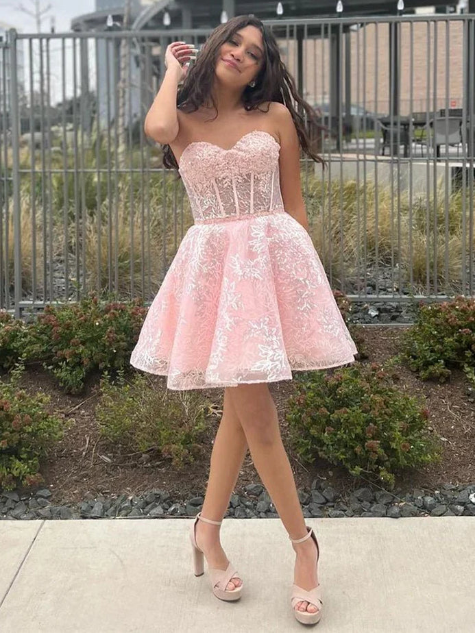 Blush pink mini homecoming dress with corset bodice, sweetheart neckline, floral lace skirt