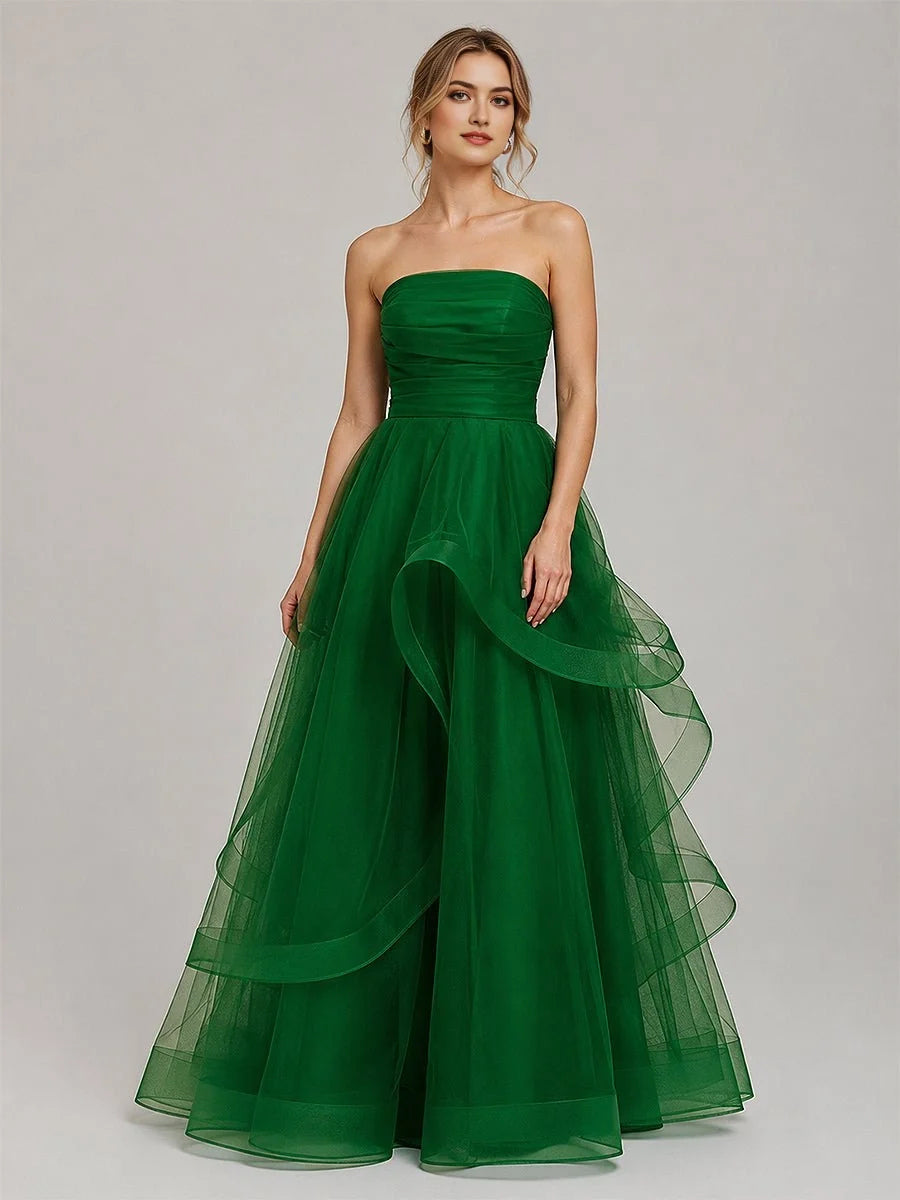 Emerald green strapless tulle ball gown with ruched corset bodice and layered ruffle skirt