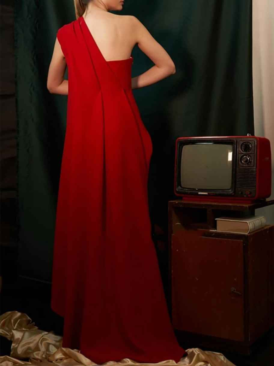 Crimson red one-shoulder floor-length formal dress with open back and flowing skirt