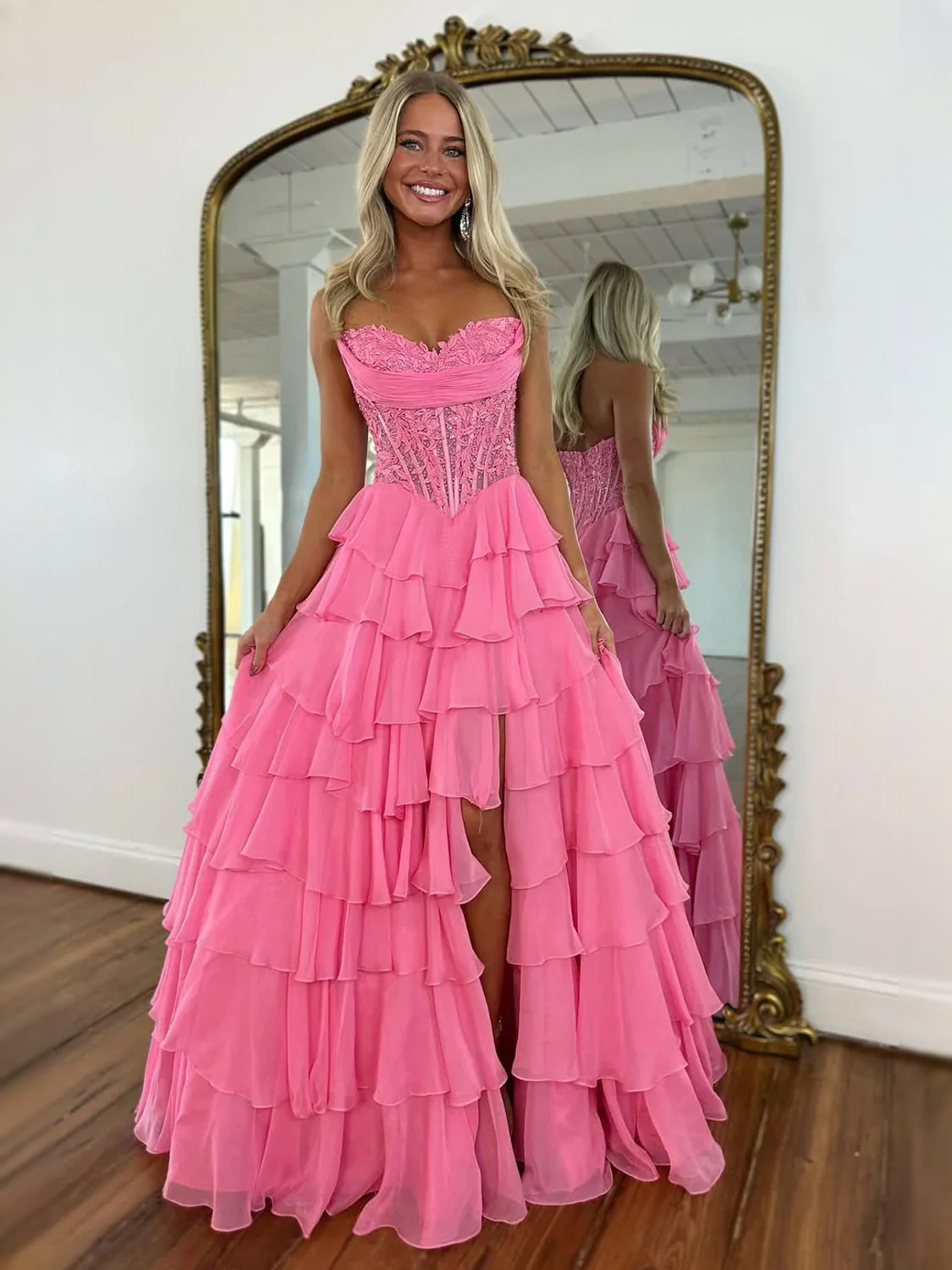 Pink strapless corset prom dress with lace bodice and tiered ruffle skirt, side slit