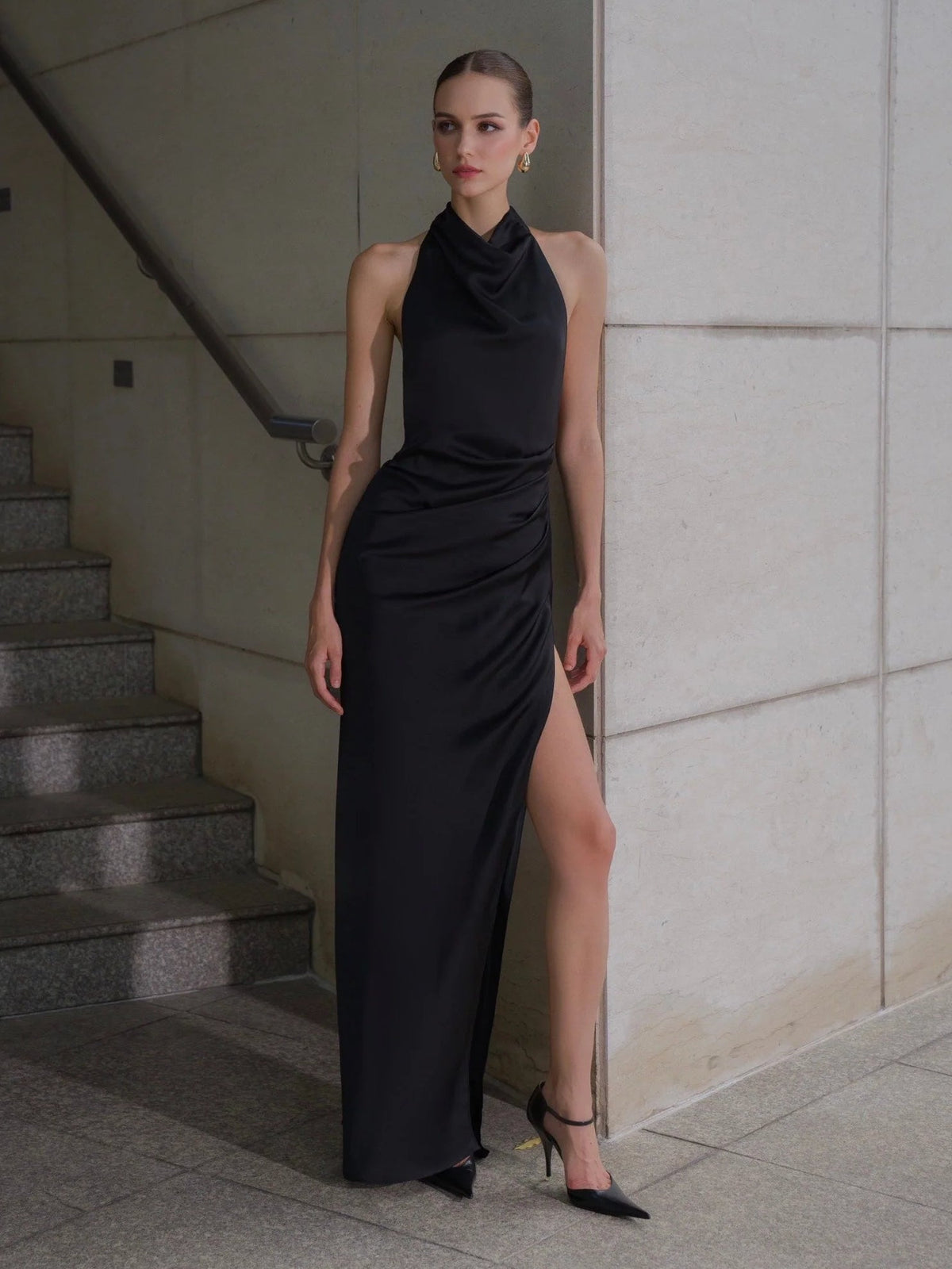 Black satin sheath maxi dress with cowl neck, ruched side, and high side slit