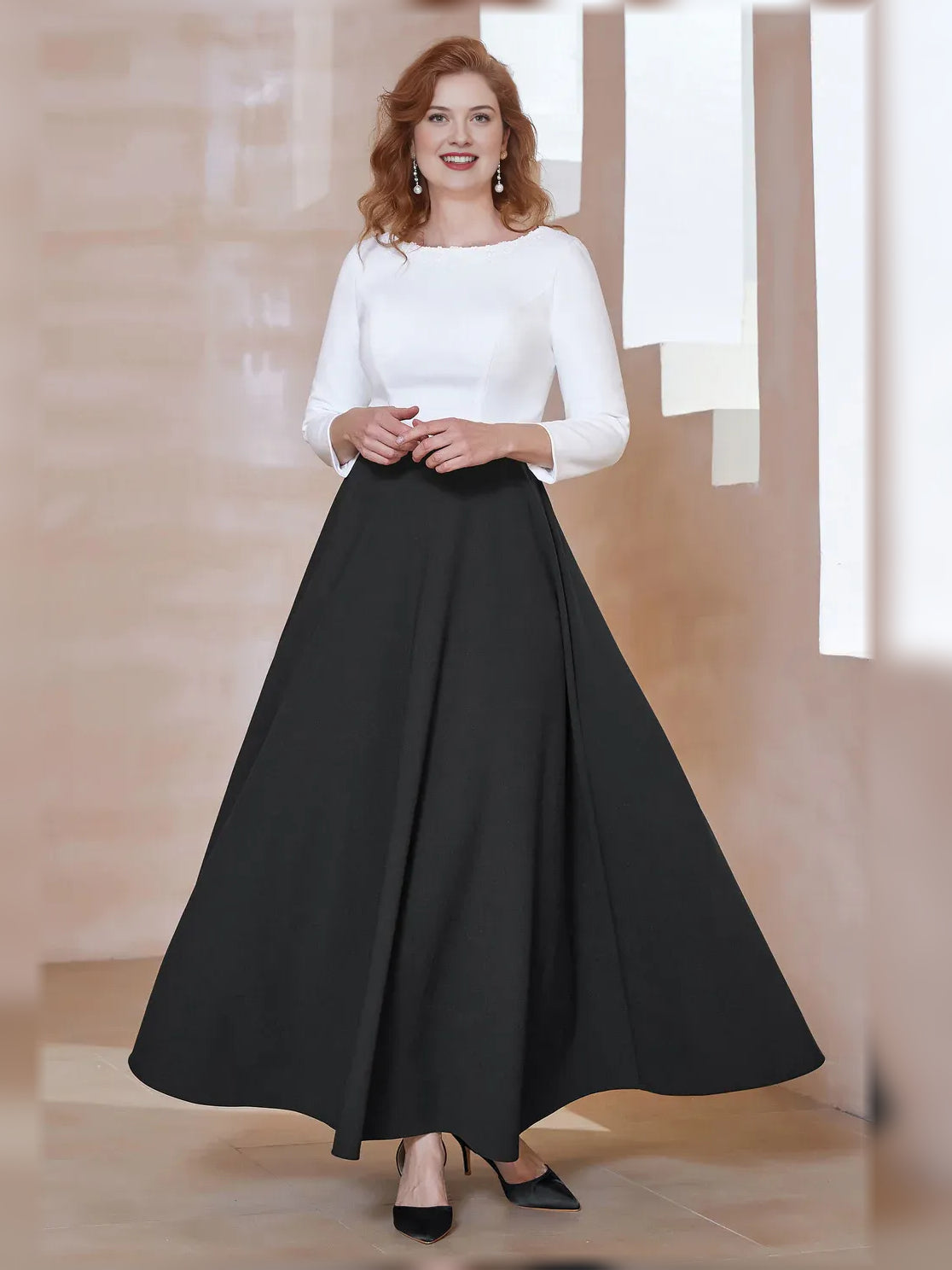 Black A-line floor-length crepe dress with boat neckline and long sleeves