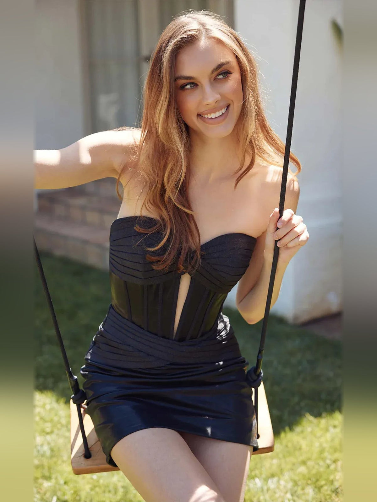 Black strapless ruched corset mini dress with open back