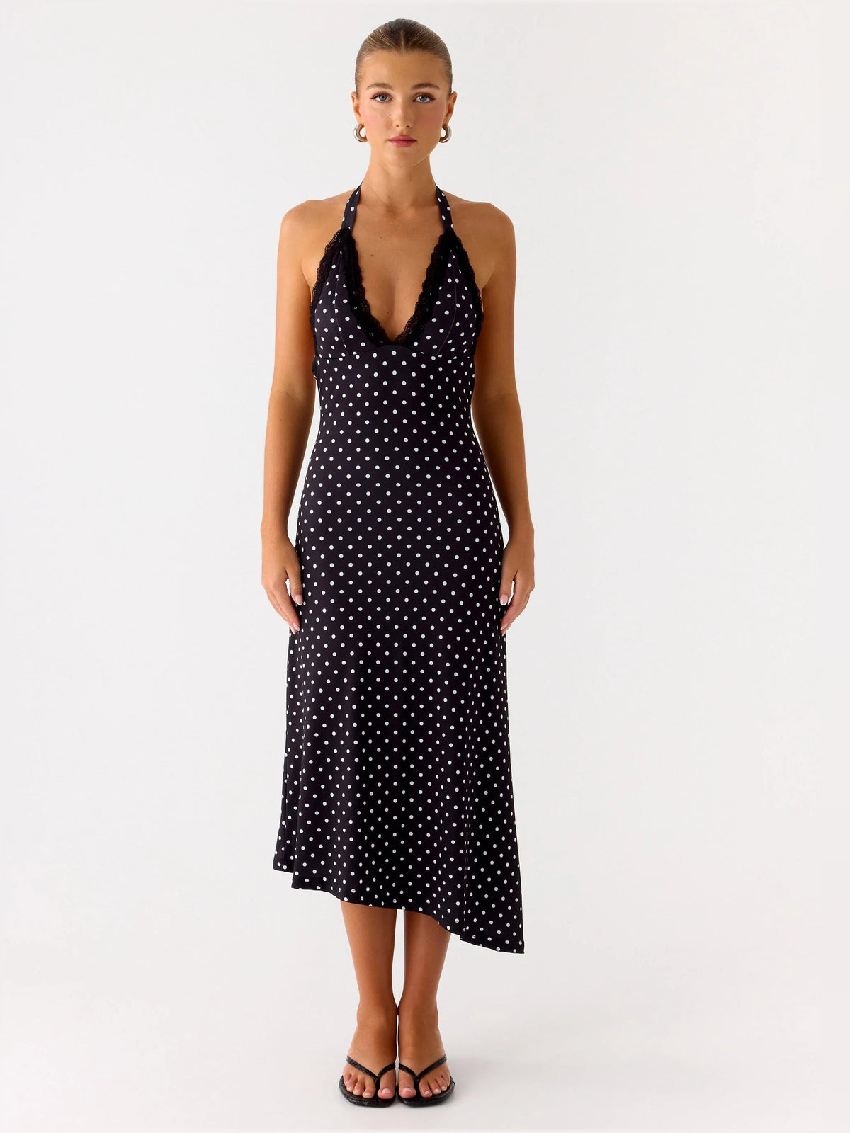 Front view of black polka-dot halter midi dress, deep V neckline and midi length