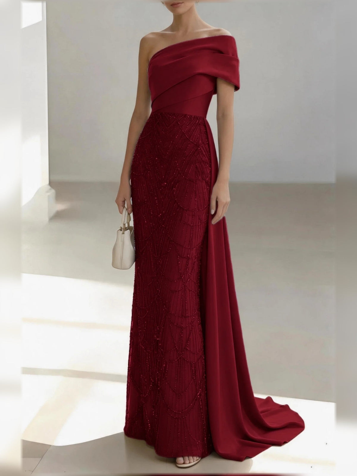 Burgundy one-shoulder satin mermaid gown with draped bow and textured lace bodice