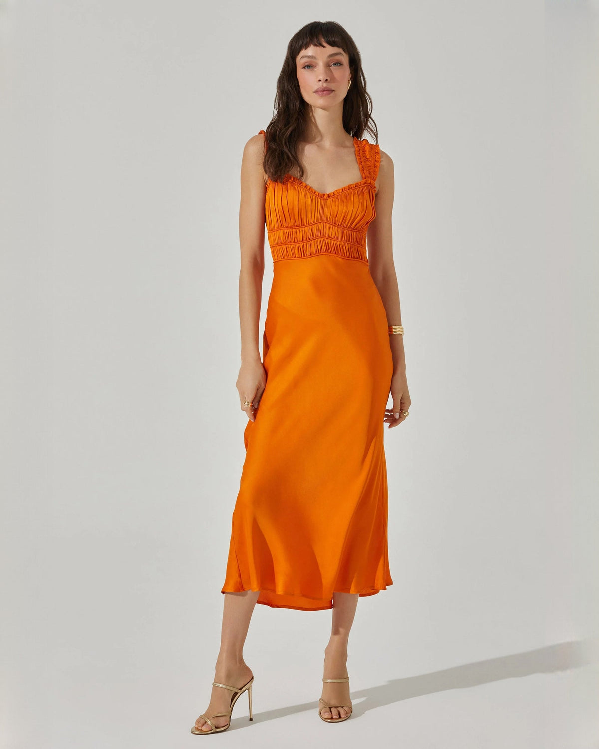 Bright orange satin sleeveless midi dress with ruched neckline and thin straps.