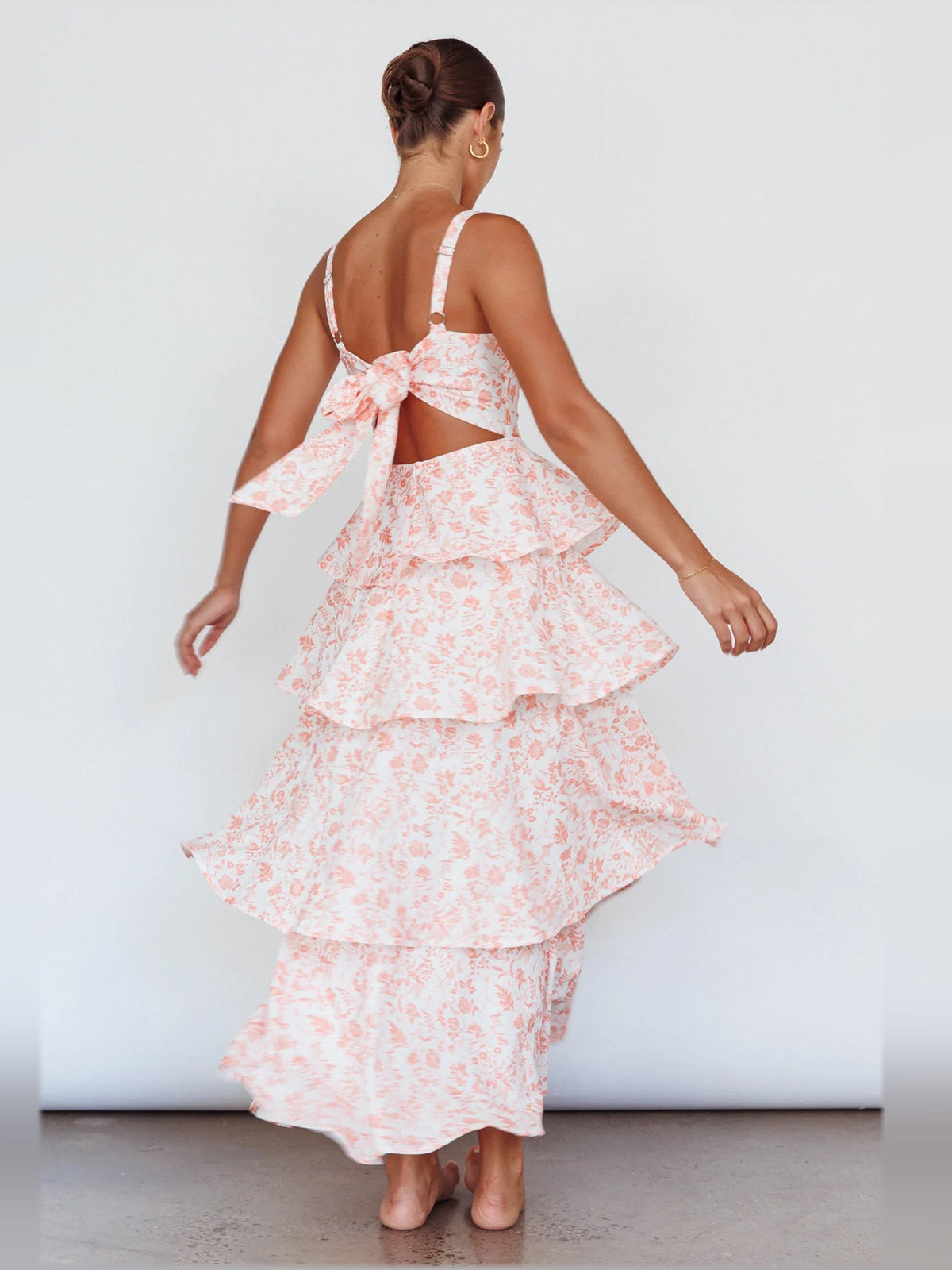 Peach floral tiered midi dress with spaghetti straps and back bow detail