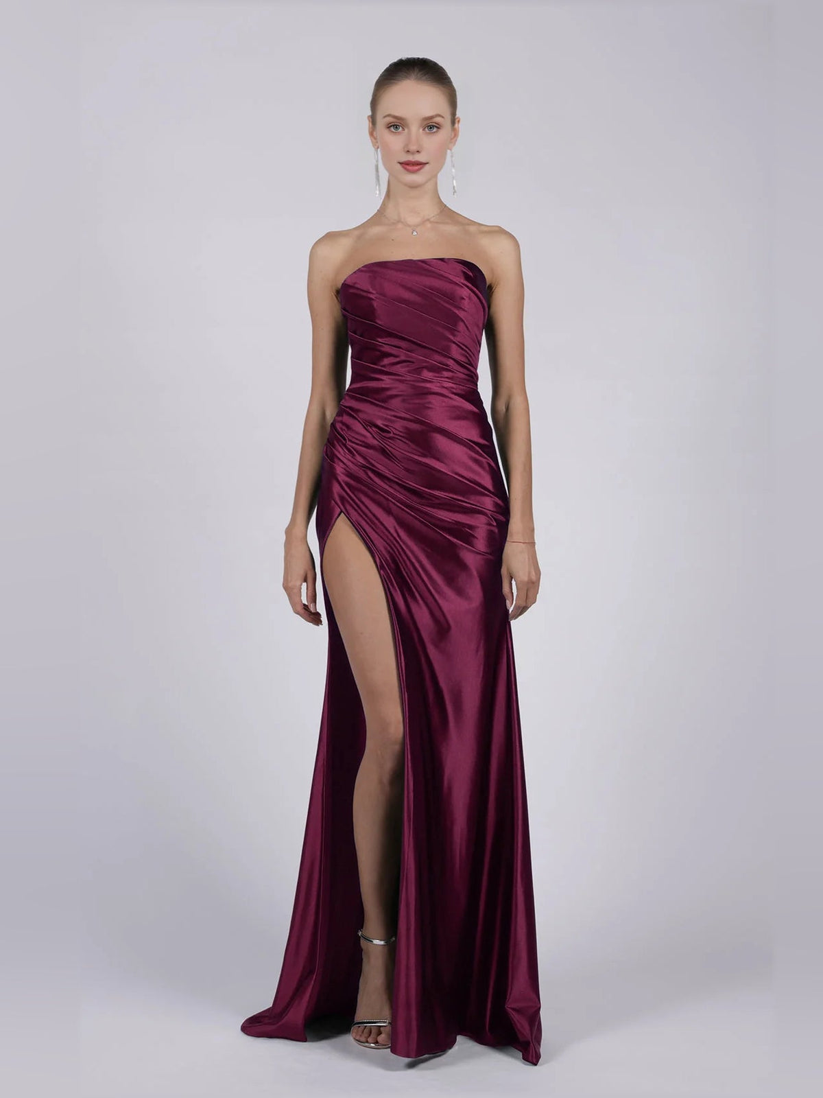 Strapless mermaid formal dress in burgundy with ruched bodice and thigh-high slit