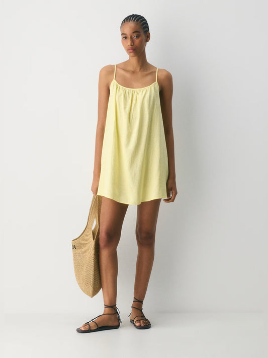 Light yellow sleeveless mini dress with thin straps, scoop neck, and gathered top