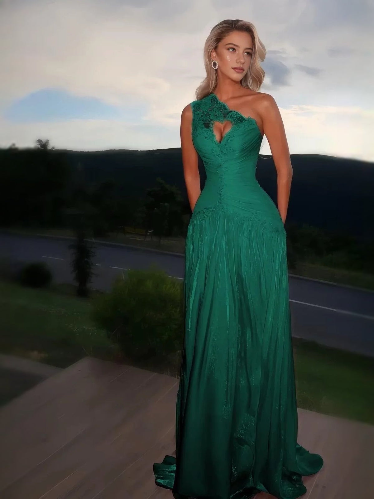 Emerald green one-shoulder prom dress with ruched bodice, heart floral applique, and A-line maxi skirt