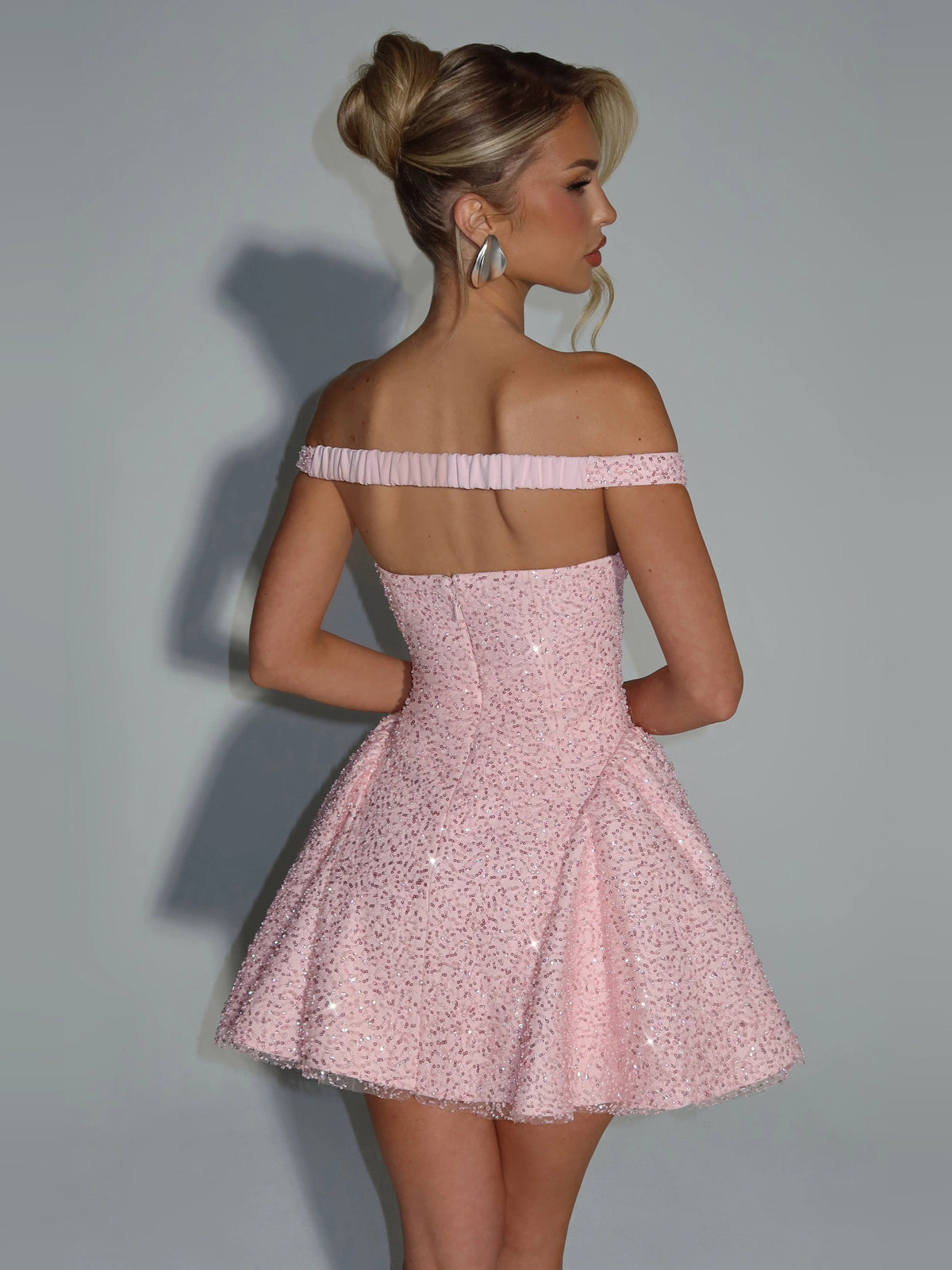 Blush pink sequined off-shoulder mini dress from side, fitted waist, flared skirt