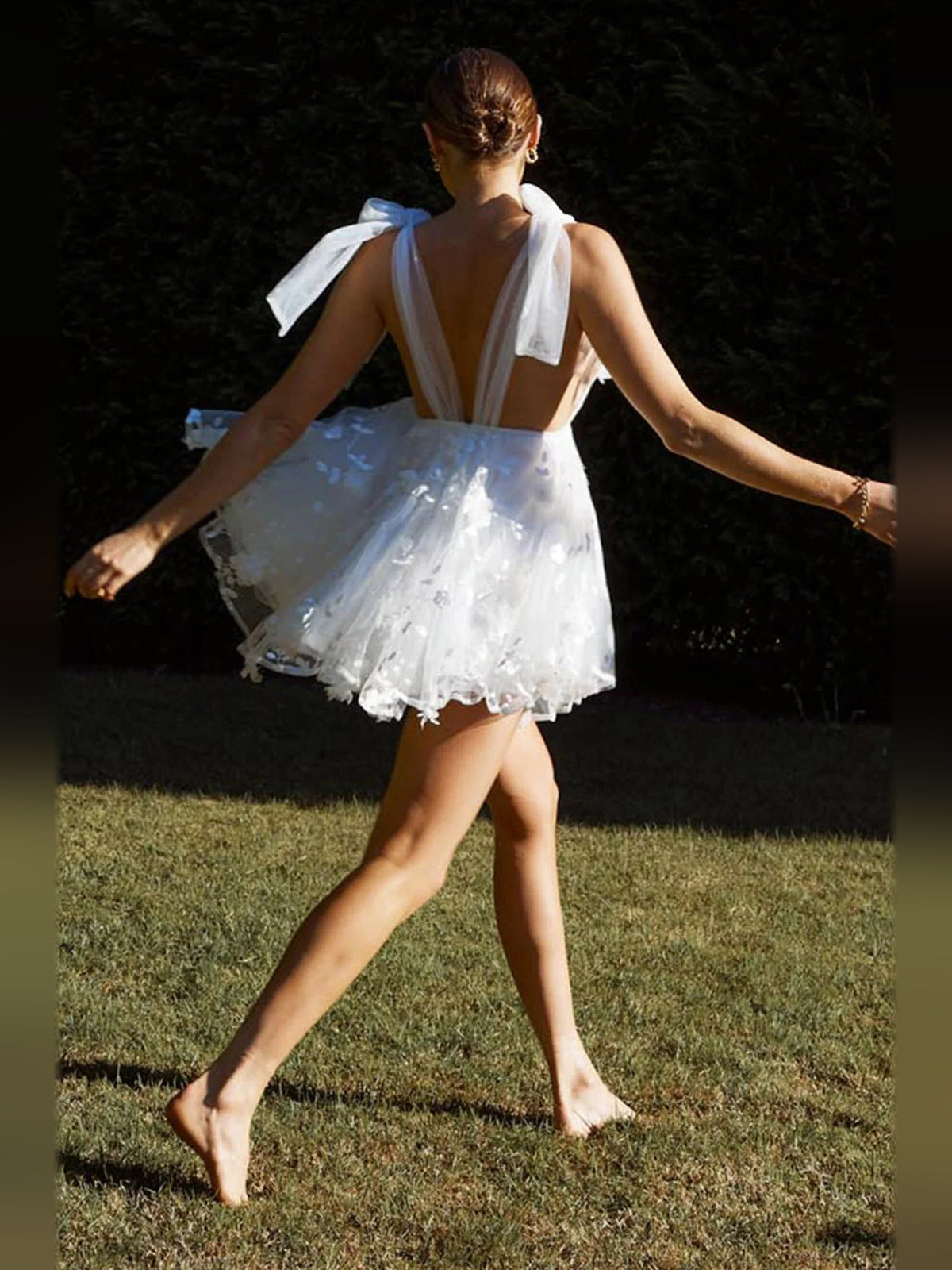 White mini homecoming dress back view with open back and sheer bow shoulder ties