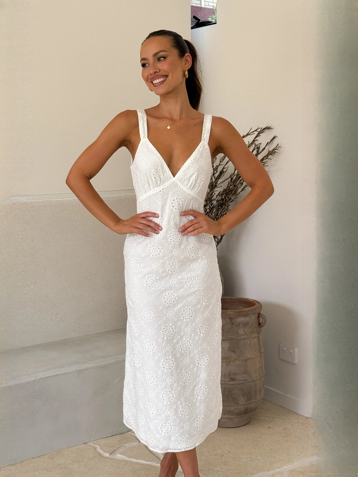 White midi formal dress with V-neck, thin straps, lace texture, studio front view