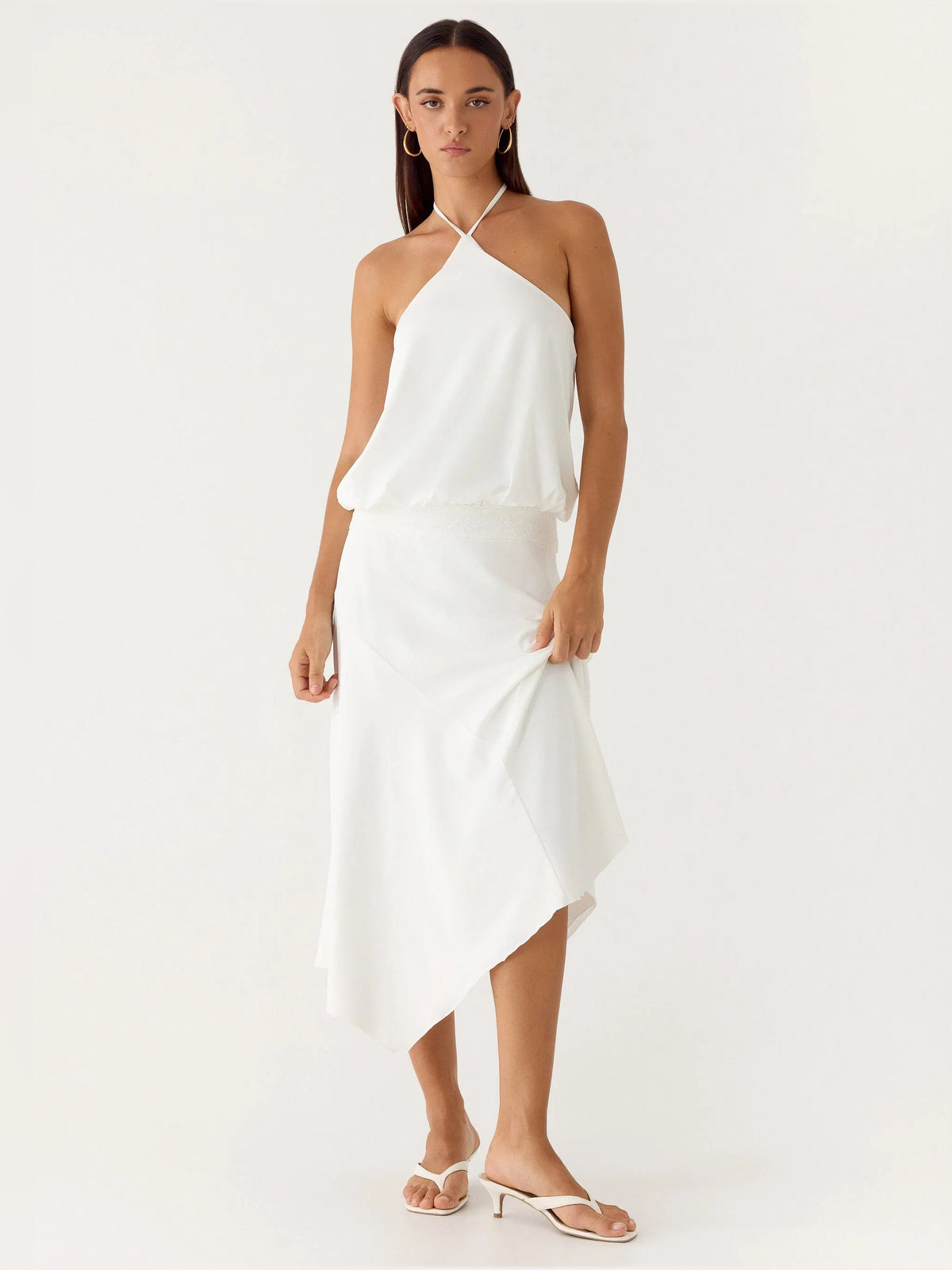 White midi formal dress with halter neckline and crossover drape, uneven hem