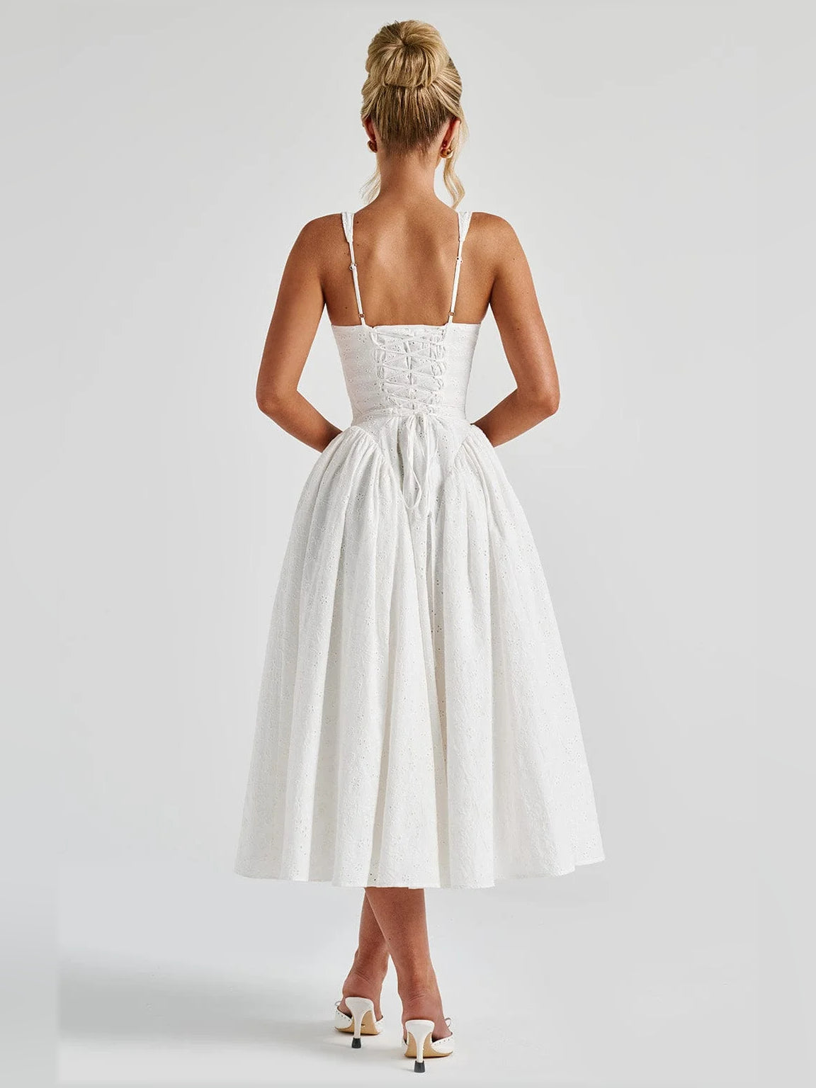 Ivory midi formal dress with open back and thin straps over a gathered skirt