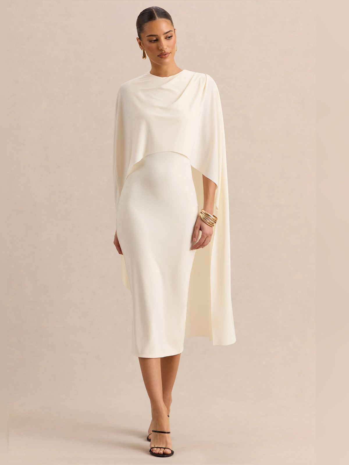 Cream midi formal dress front view with round neckline, fitted body, and flowing cape sleeves