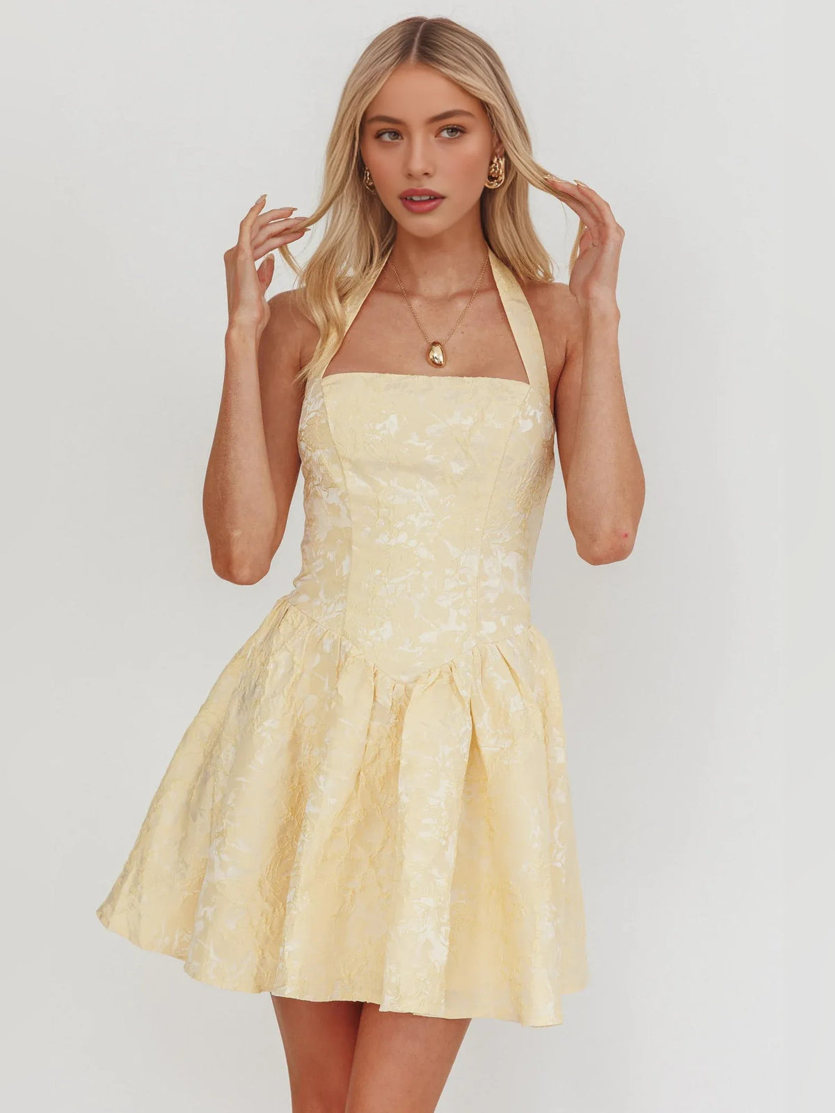 Pale lemon halter-neck corset mini dress with flared A-line skirt and textured detail