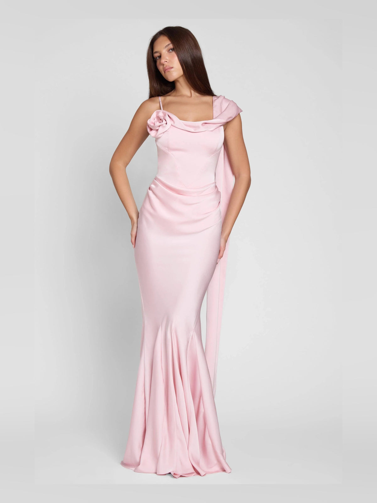 Pink mermaid prom dress with off-shoulder drape, asymmetrical neckline, and rosette detail