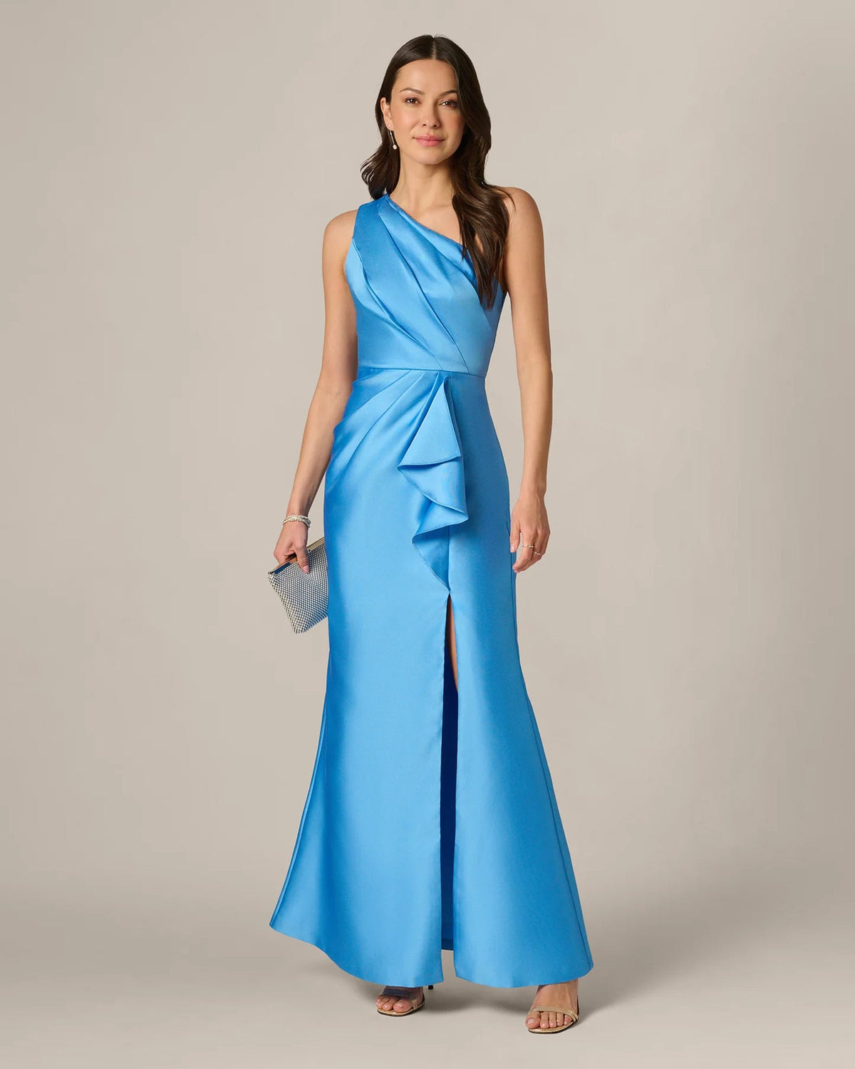 Sky blue one-shoulder draped maxi gown with ruffle accent; holds small clutch
