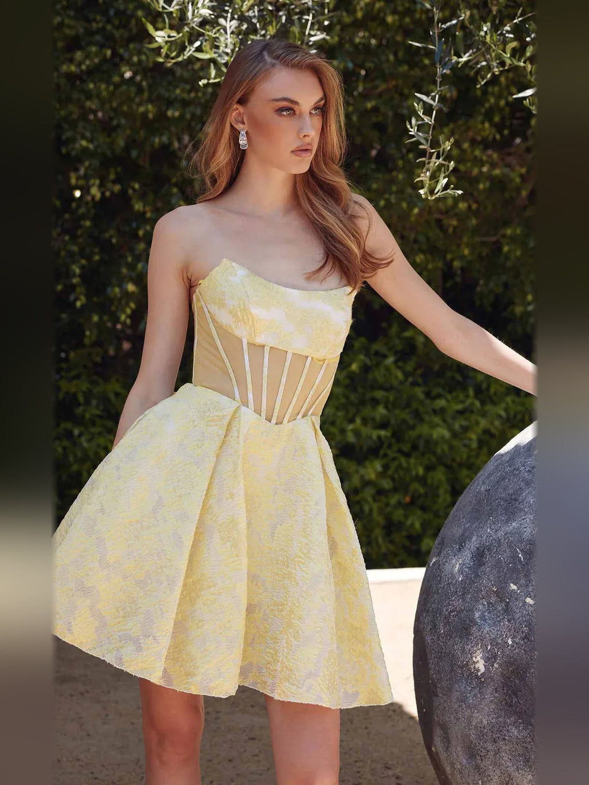 Pale lemon strapless corset A-line short dress outdoors with fitted bust and waist seams