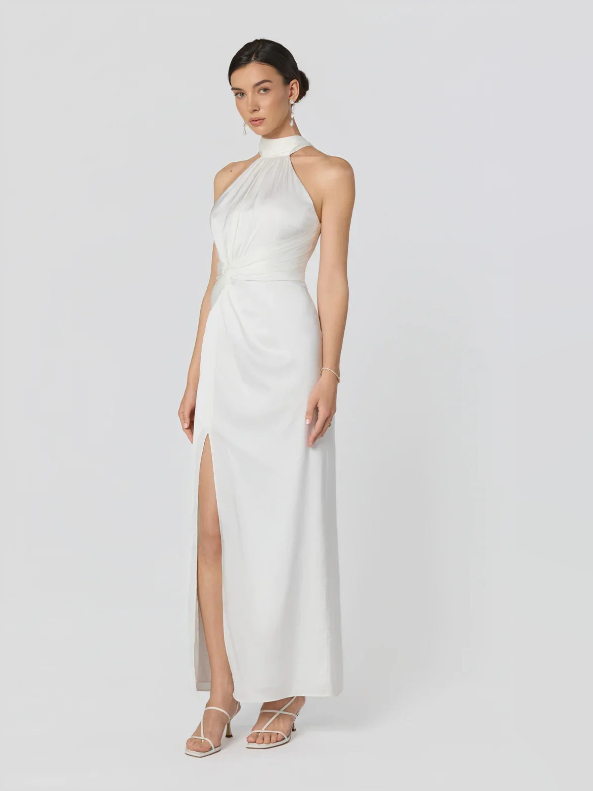 Ivory halter-neck fitted formal dress with open back and front slit, floor-length
