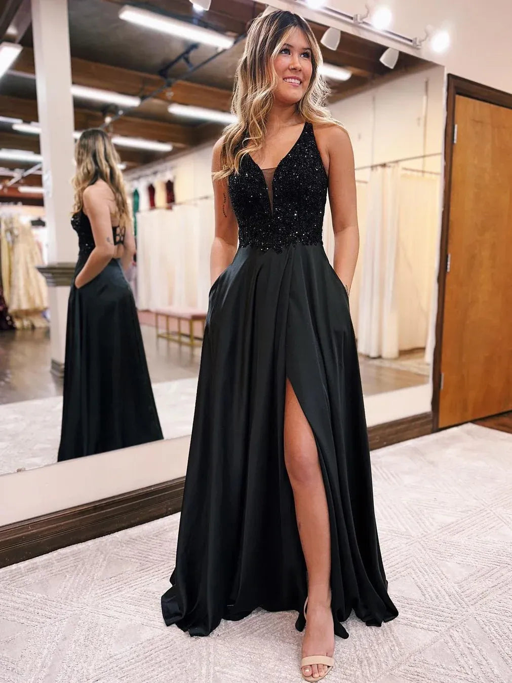 Black V-neck spaghetti strap gown with front slit and flowing floor length