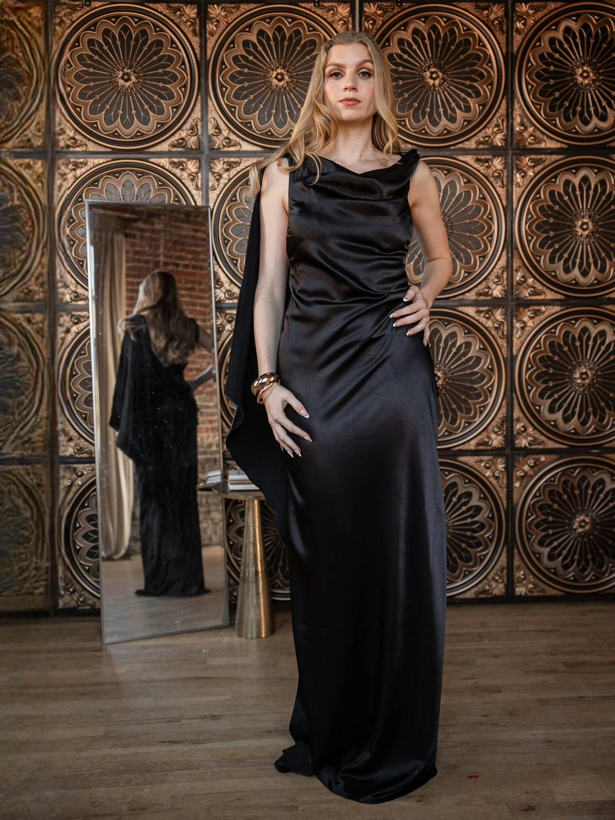Black satin draped cowl-neck sheath wedding dress with sleeveless cut and floor-length hem