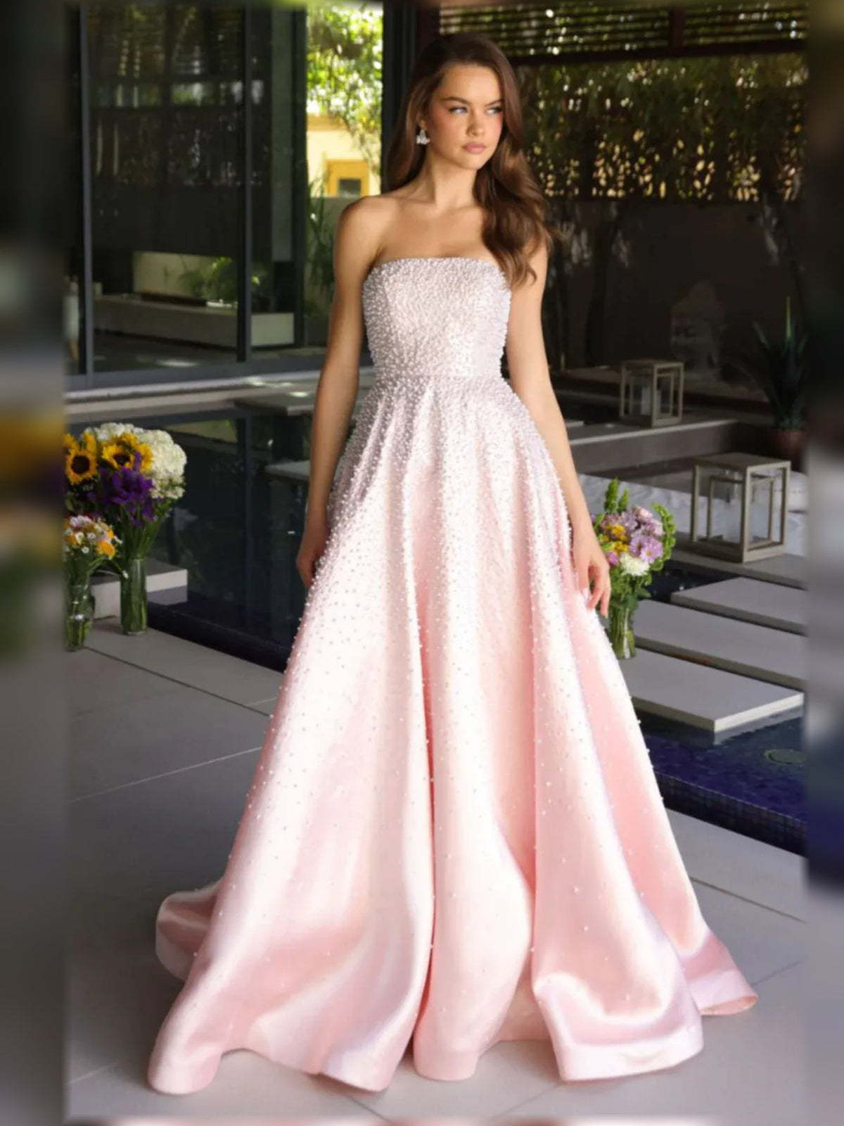 Blush pink strapless beaded corset formal dress with full floor-length skirt.