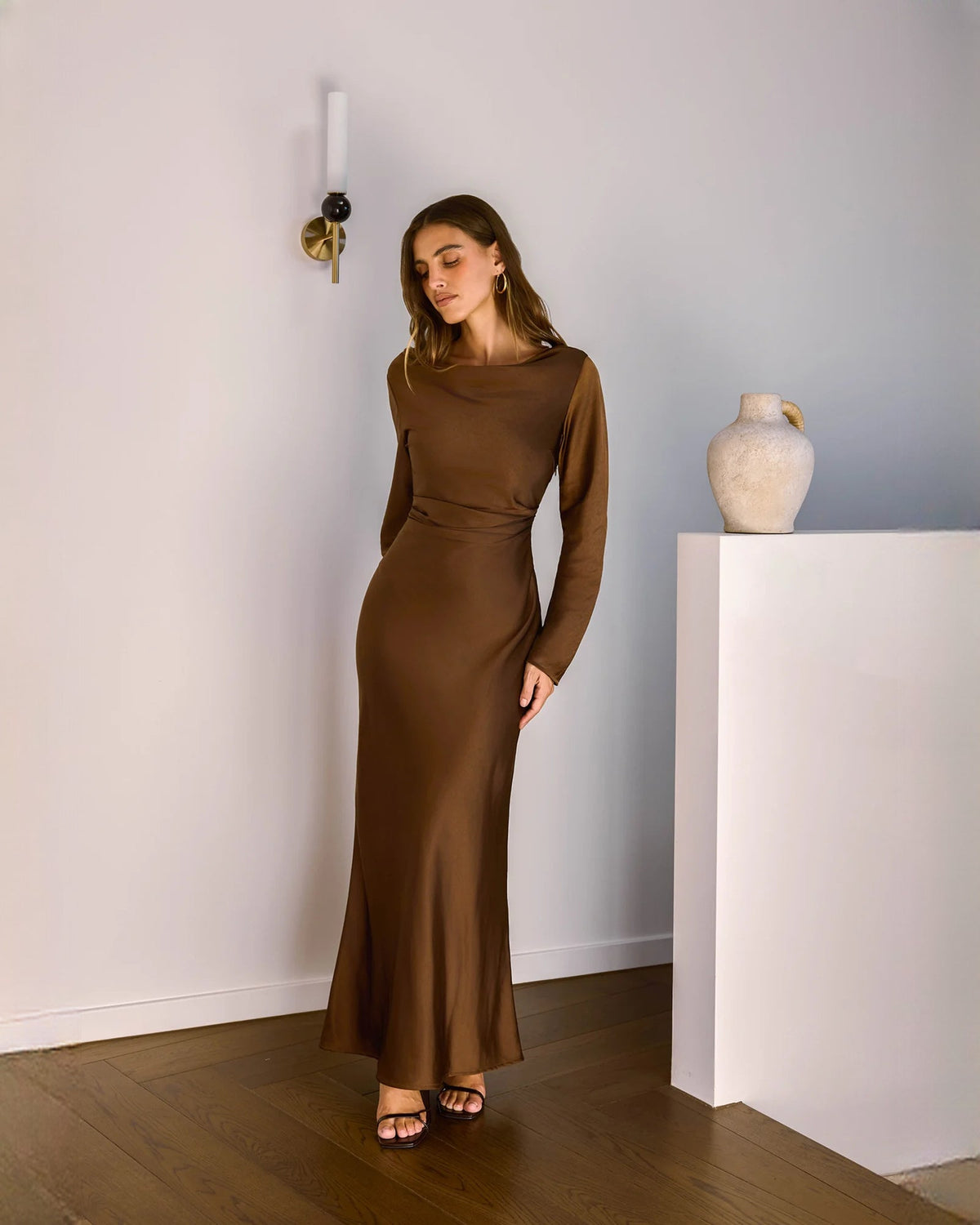 Chocolate brown satin maxi dress with long sleeves, draped neckline, and flared A-line hem