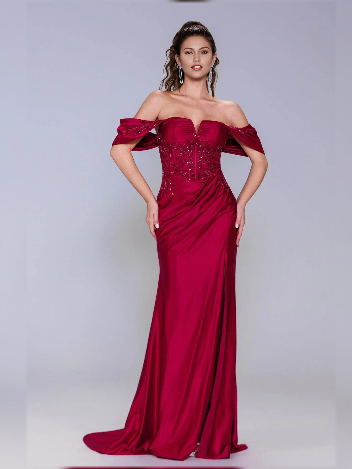 Deep red off-shoulder formal dress with ruched sweetheart bodice and flowing slit skirt.