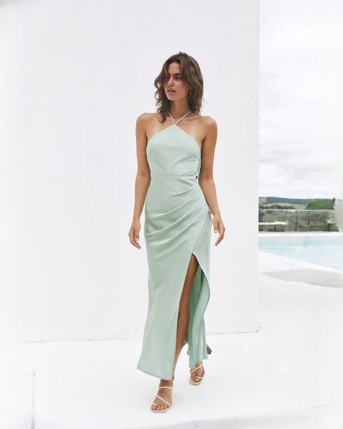 Sage green satin halter midi dress with draped front, thin straps, and side slit
